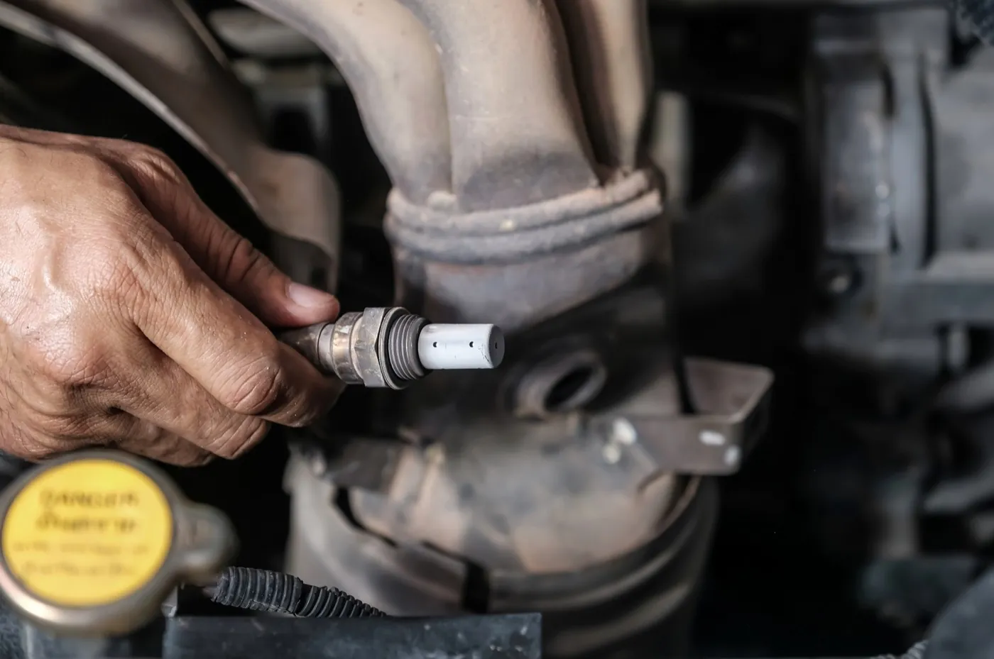 Technician checking and changing the oxygen sensor on a car
